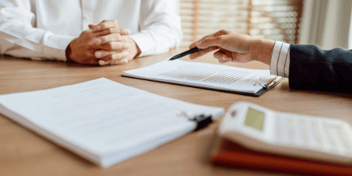 two people reviewing documents at a desk 