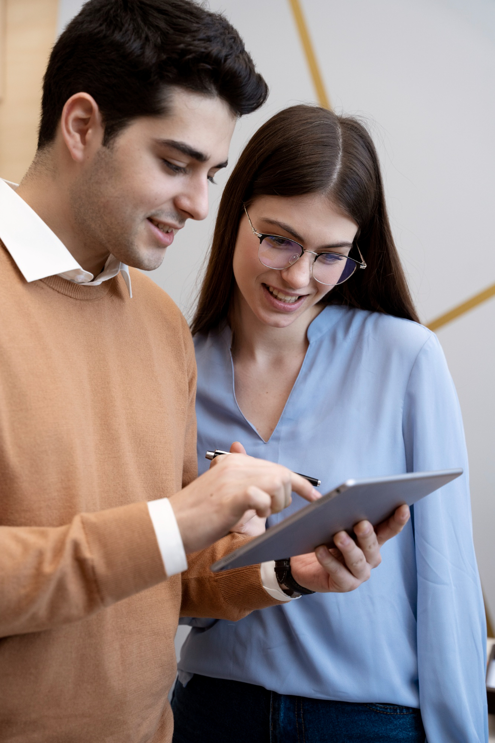 two people looking at a tablet discussing work together