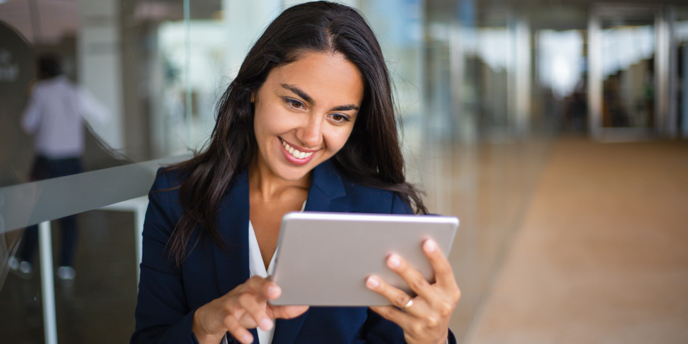 woman looking at work tablet smiling