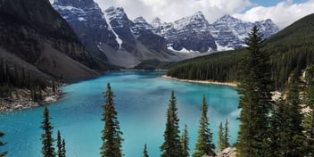 a clear blue lake nestled in the rocky mountains