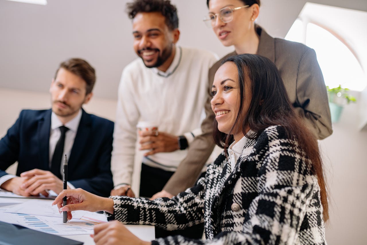 4 colleagues working together around one computer