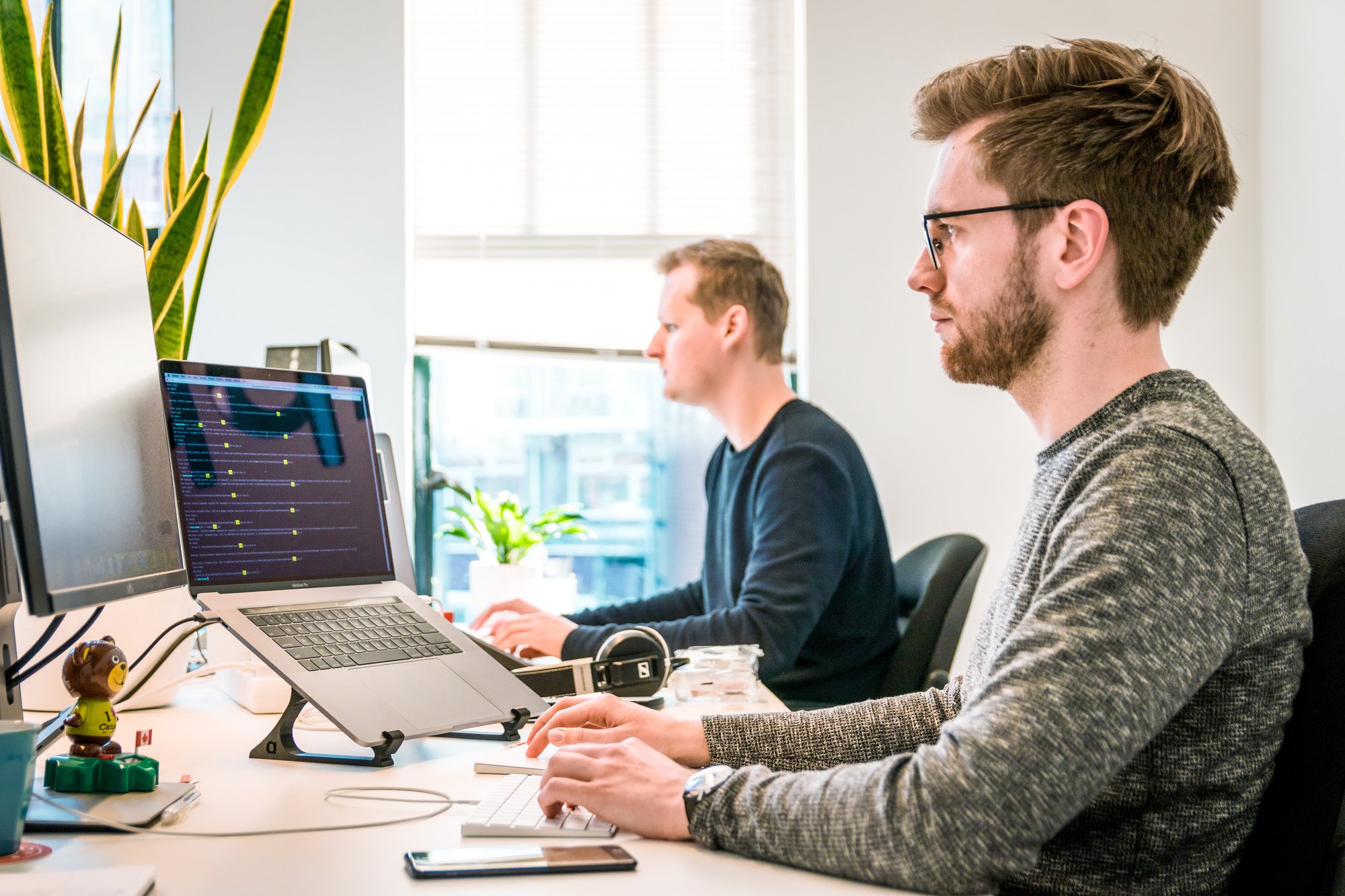 two people working side by side at a shared esk