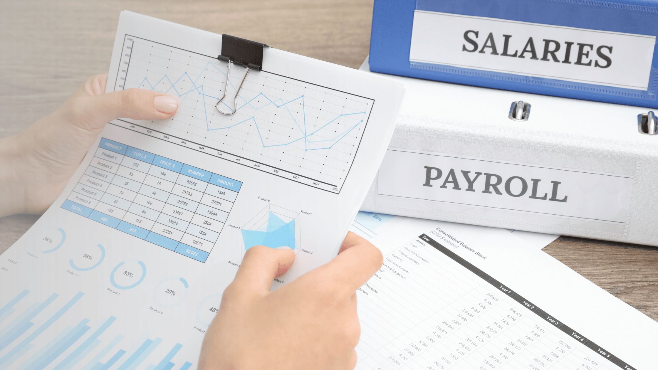 Someone reviewing a tax file with salaries and payroll binders in the background